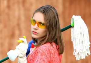 Woman preparing to clean with mop and spray bottle